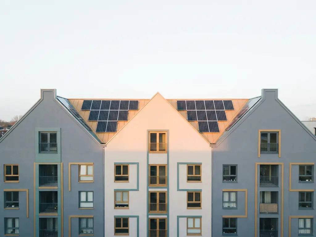 Rij Nederlandse appartementsgebouwen met zonnepanelen op een warm verlicht dak, minimalistische geometrische stijl in gedempte tinten.